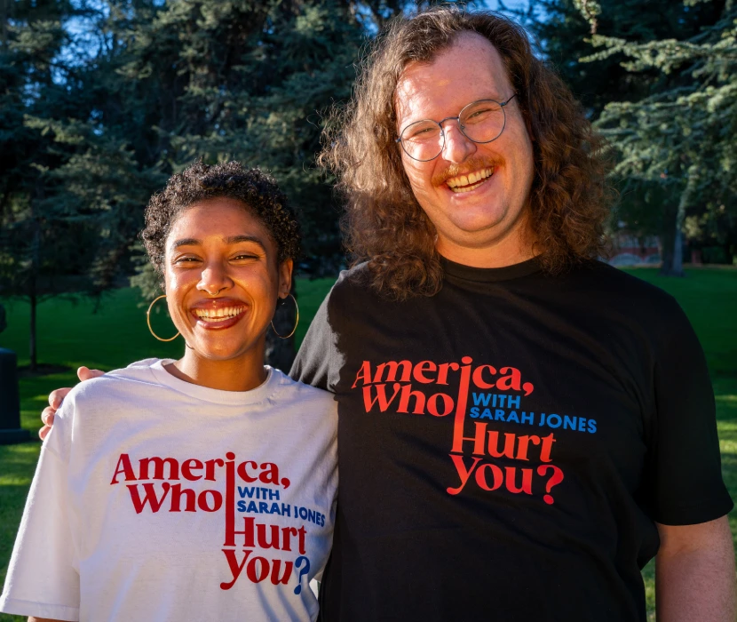 Two people wearing slogan t-shirts in park